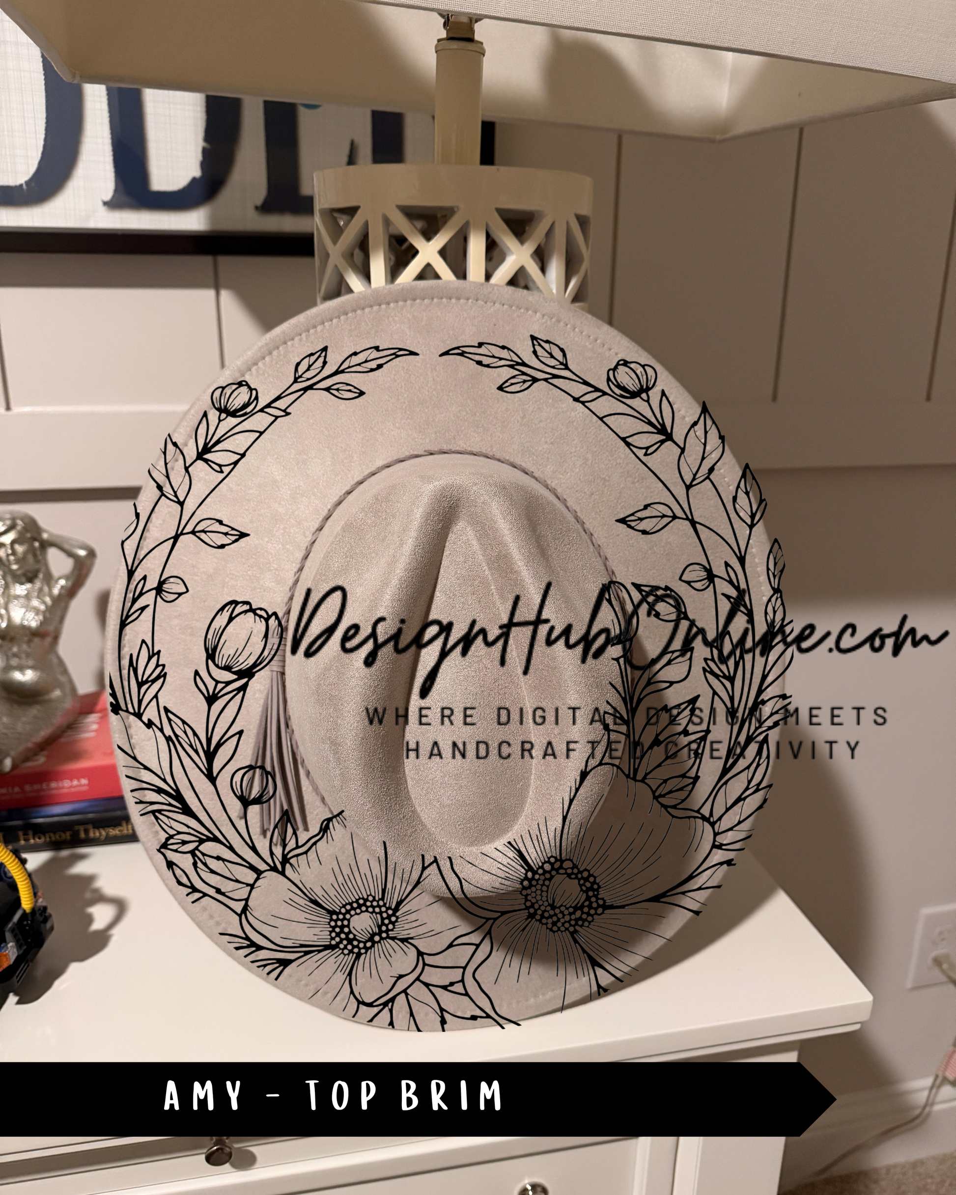A white hat with a floral design on it, placed on a white dresser.
