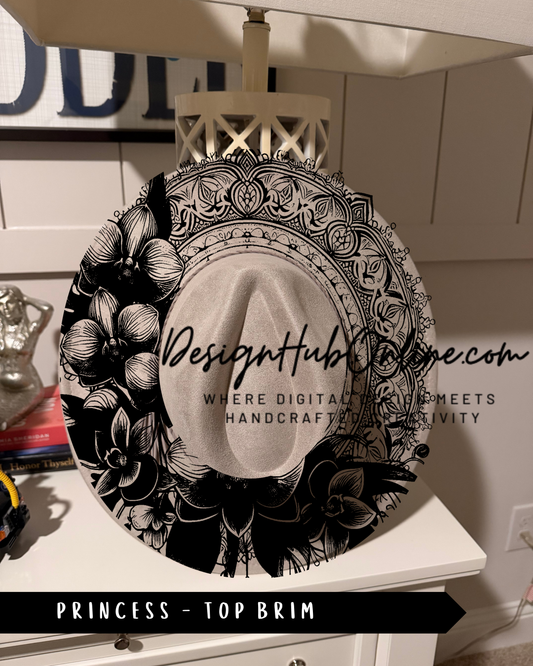 A decorative black and white hat with floral and geometric patterns, placed on a white surface.