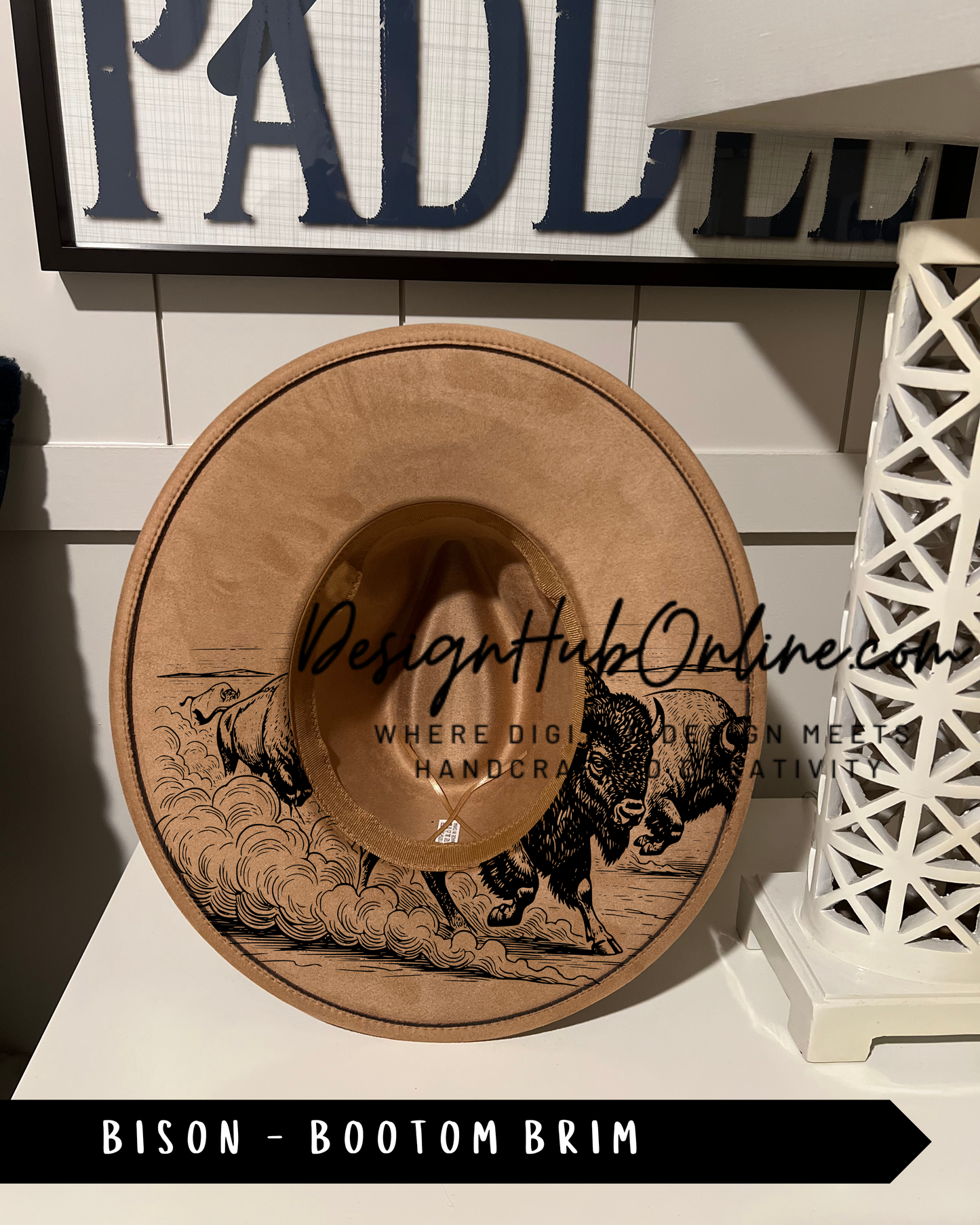 A wooden hat with a bison design on it, displayed on a shelf.