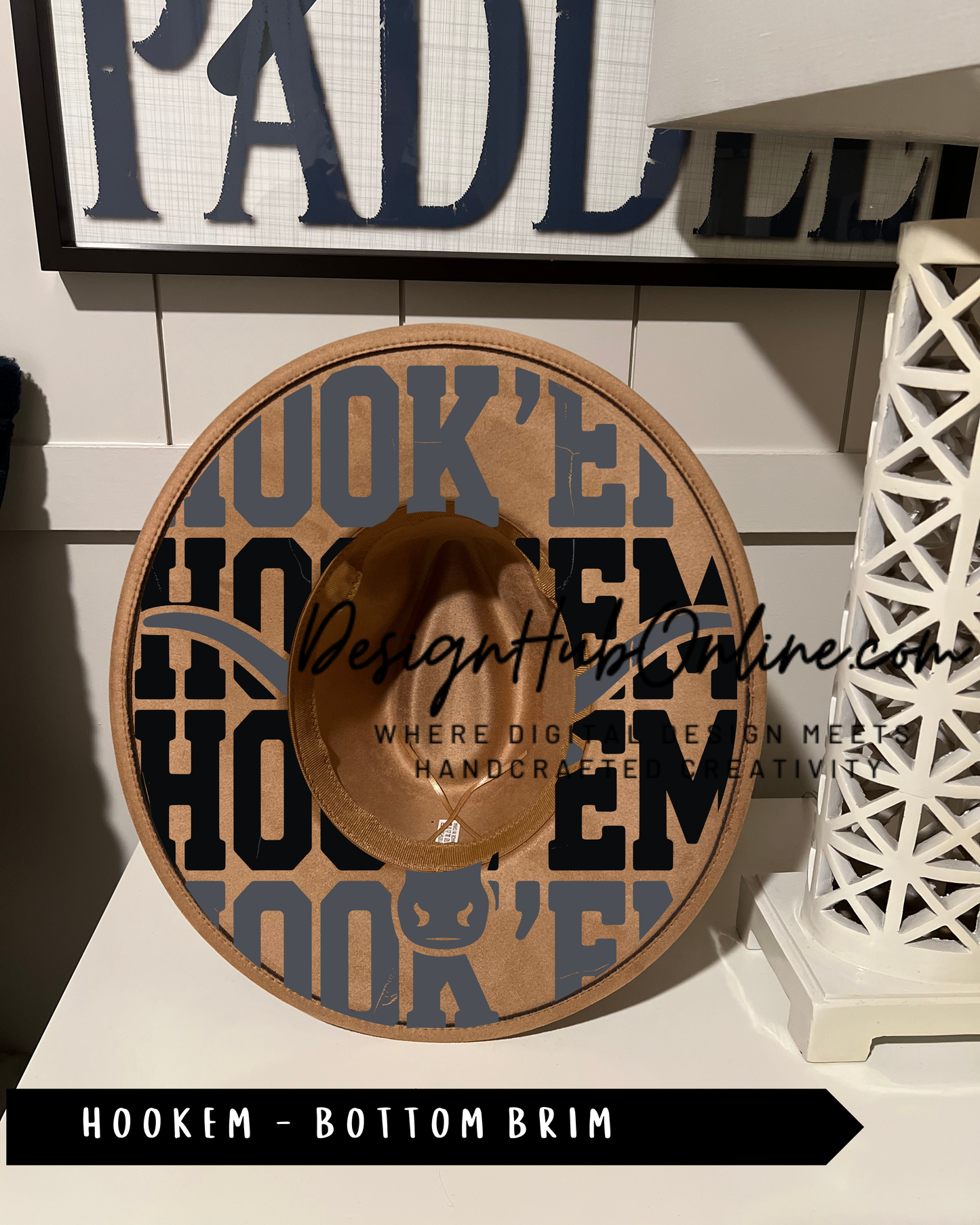 A hat with a unique design featuring the word "HOOKEM" in a stylized font, displayed on a shelf.