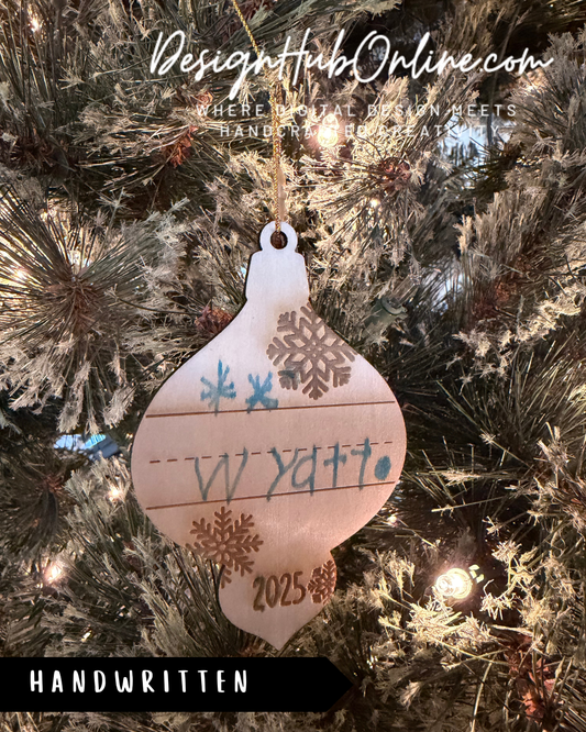 A handcrafted ornament with a snowflake design hangs on a Christmas tree, featuring handwritten text that reads "Wyatt 2015".