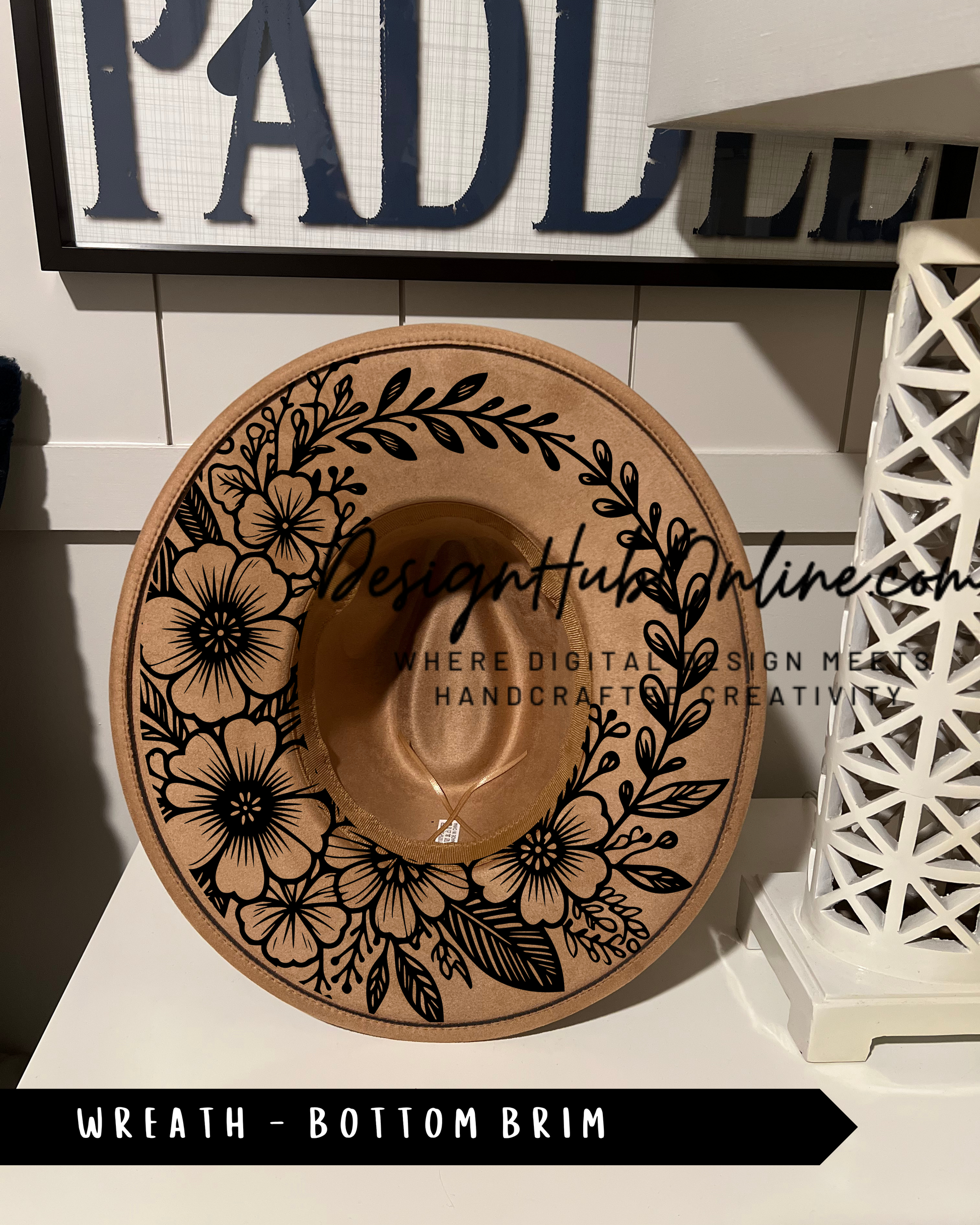 A decorative brown hat with a floral design on the front, placed on a white surface.