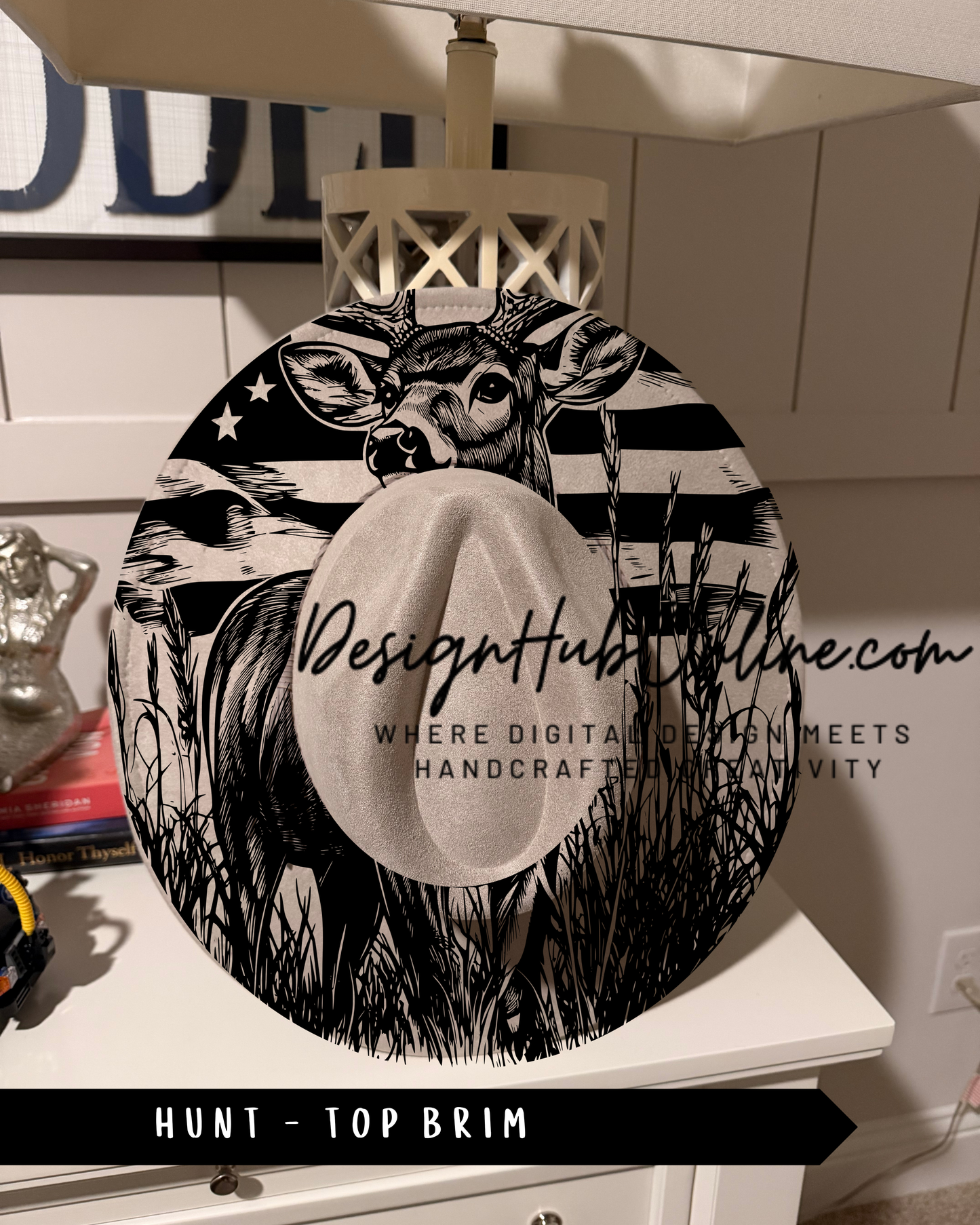 A black and white image of a deer wearing a top brim hat, with the text "DesignHUB.COM" and "HUNT - TOP BRIM" printed on it.