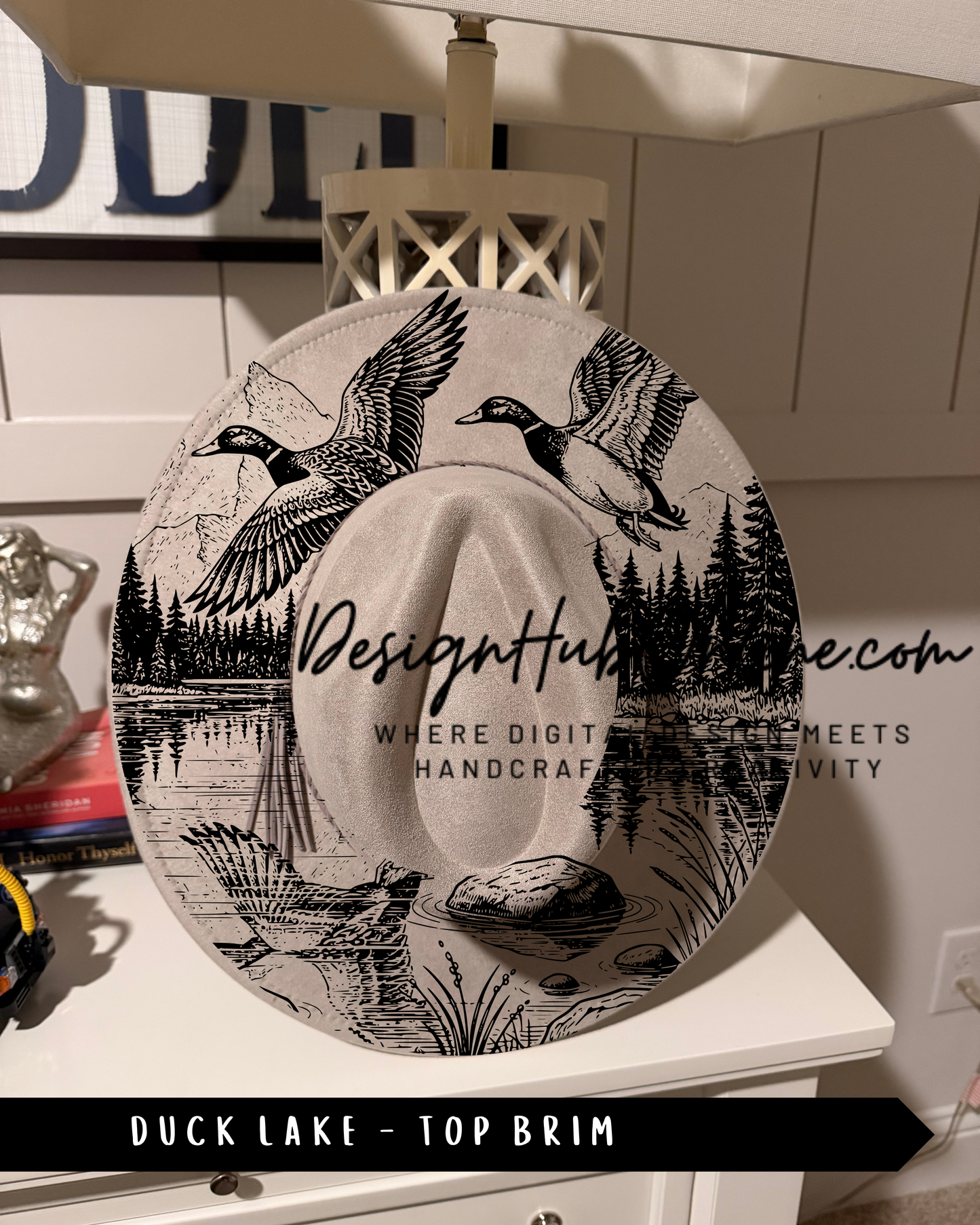 A hat with a printed design of ducks and a lake, along with the text "Design Hub" and "Where digital meets handicraft".