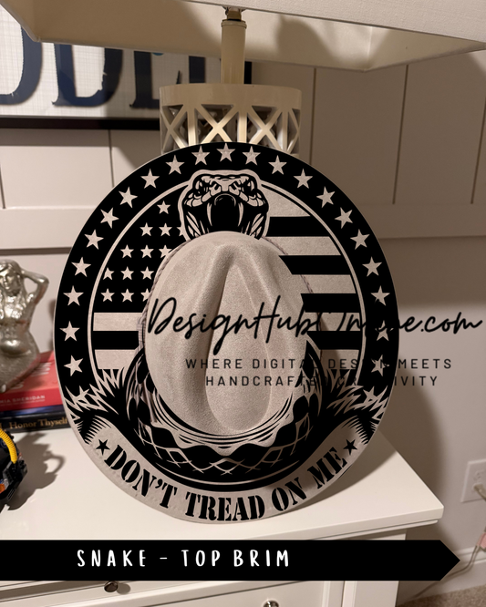 A black and white image of a hat with a snake design, featuring the text "Don't Tread on Me" and "Top Brim" printed on it.