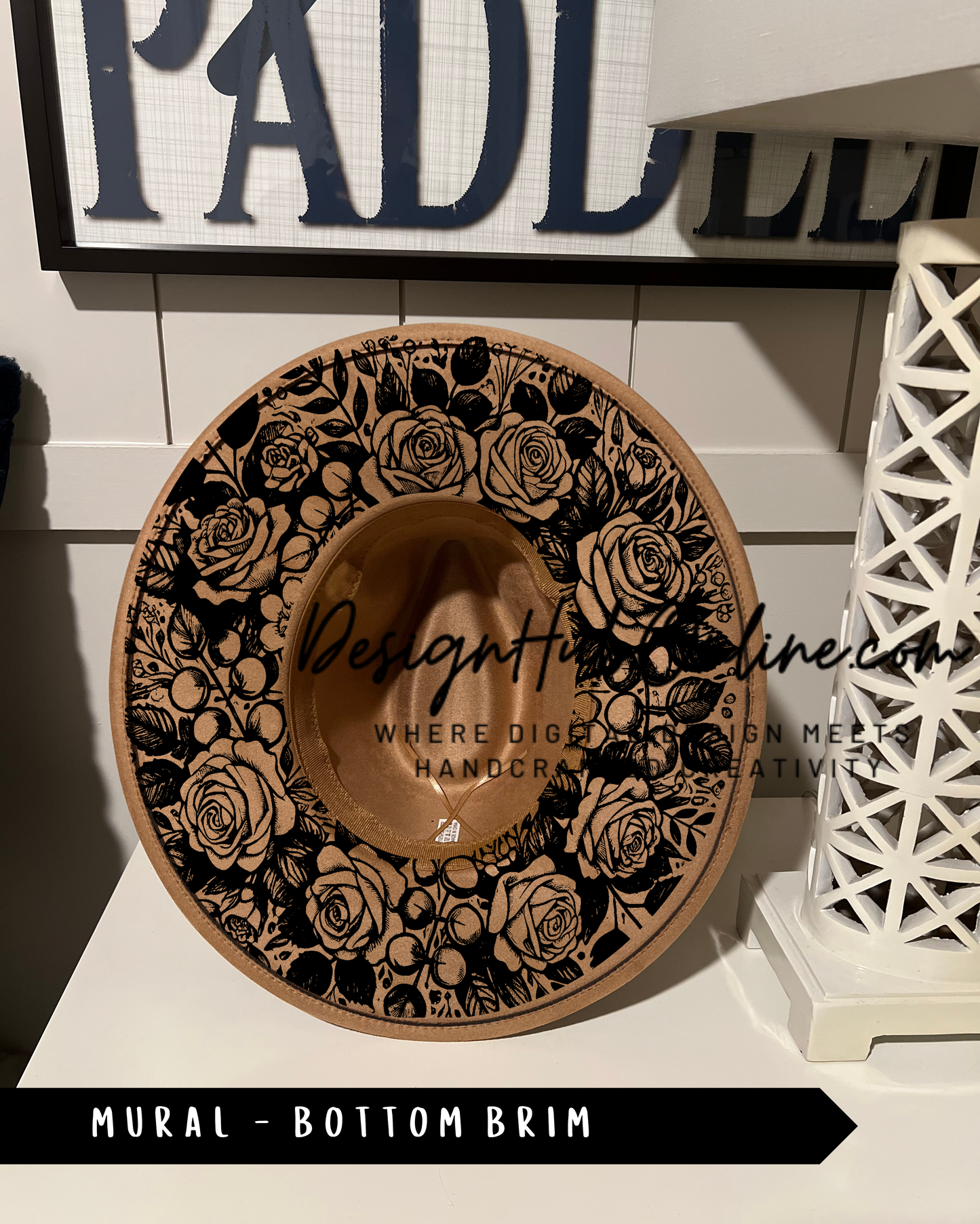 A decorative hat with a floral pattern on the brim, displayed on a shelf.