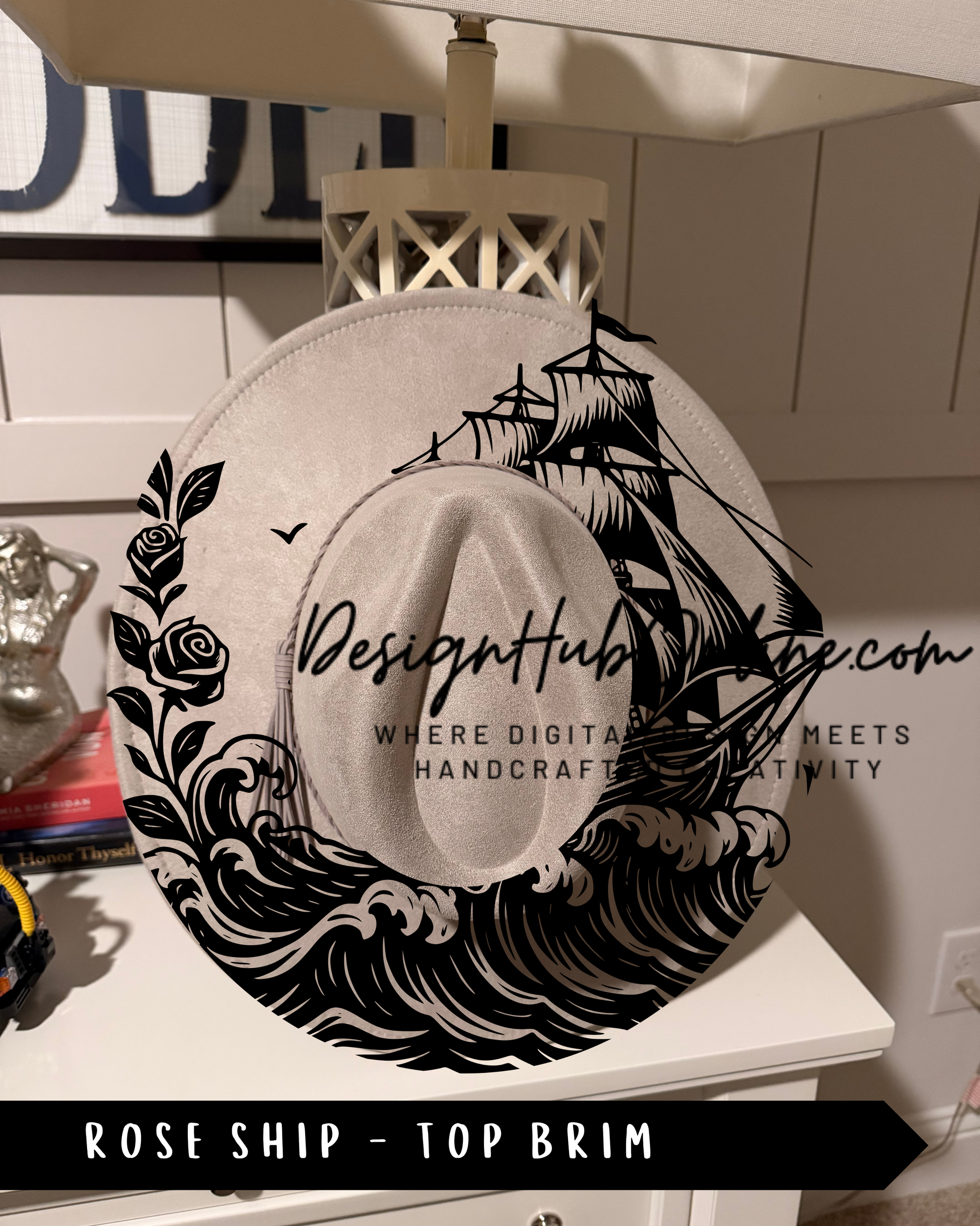 A hat with a ship design and a rose on the side, displayed on a shelf.