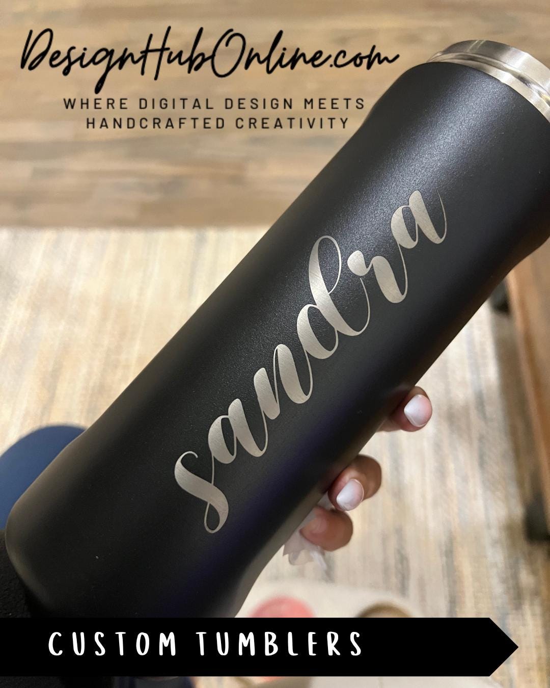 A close-up view of a black tumbler with the name "Sandria" engraved on it.