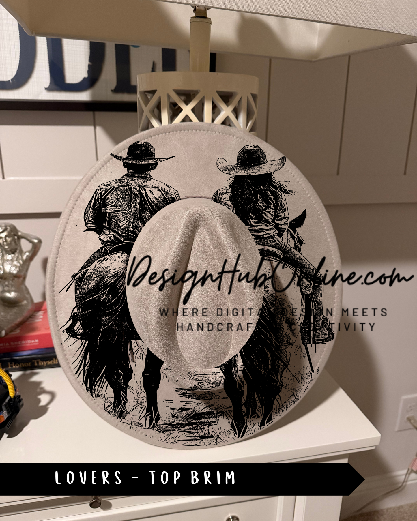 A hat with a graphic design featuring two people riding horses, with text that reads "Design Hub Online" and "Where digital design meets handicraft".