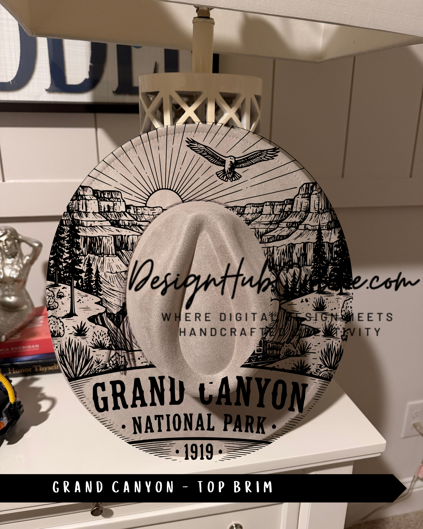 A decorative hat with a printed design of the Grand Canyon, featuring a sun, eagle, and mountains.