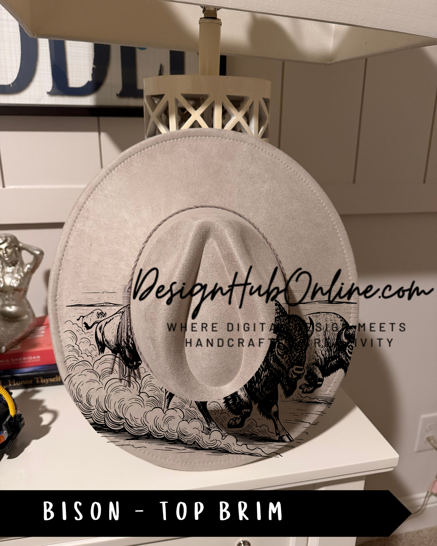 A white hat with a graphic of a bison on it, placed on a white surface.