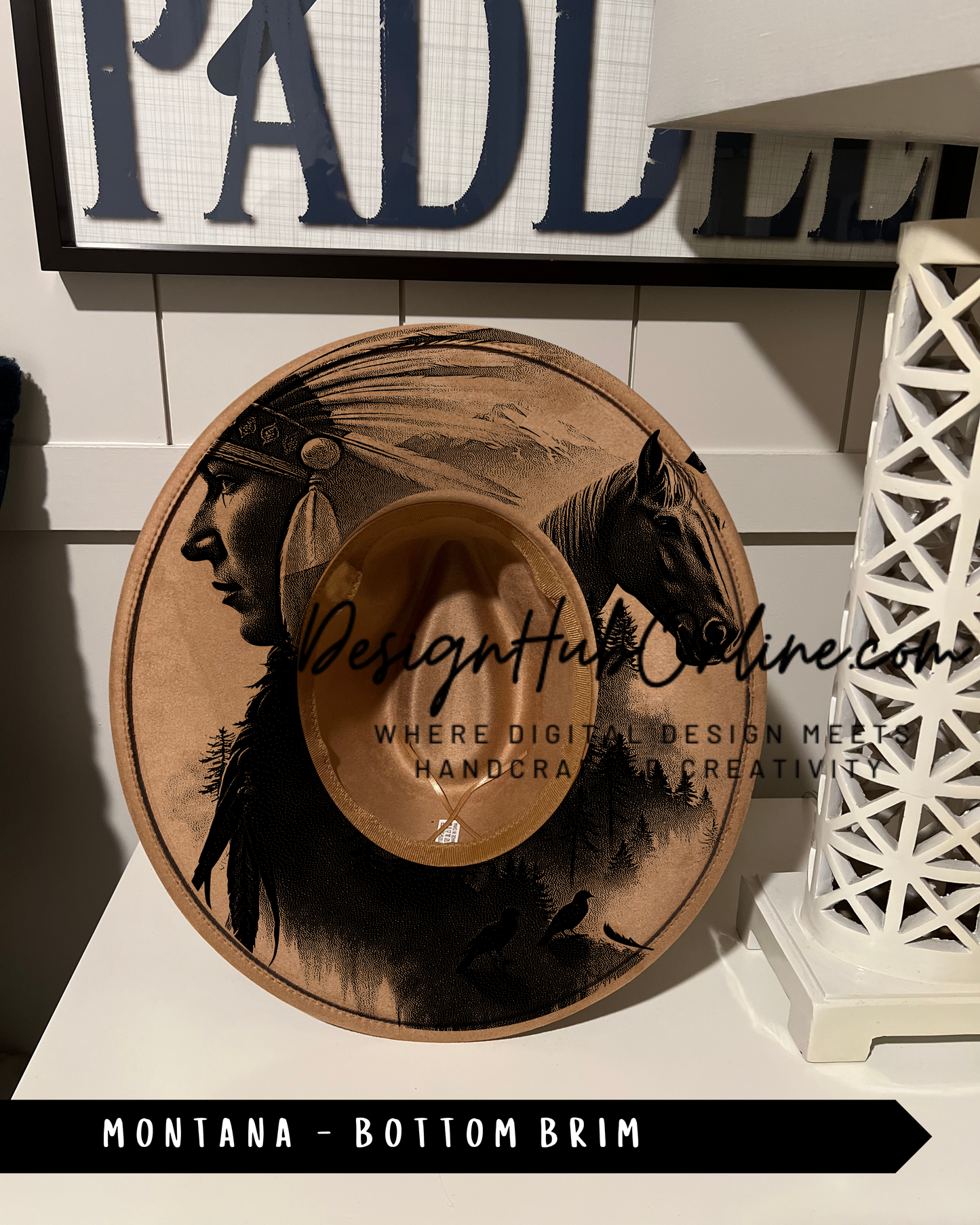 A hat with a Native American design, featuring a profile of a person wearing a headdress, is displayed on a shelf.