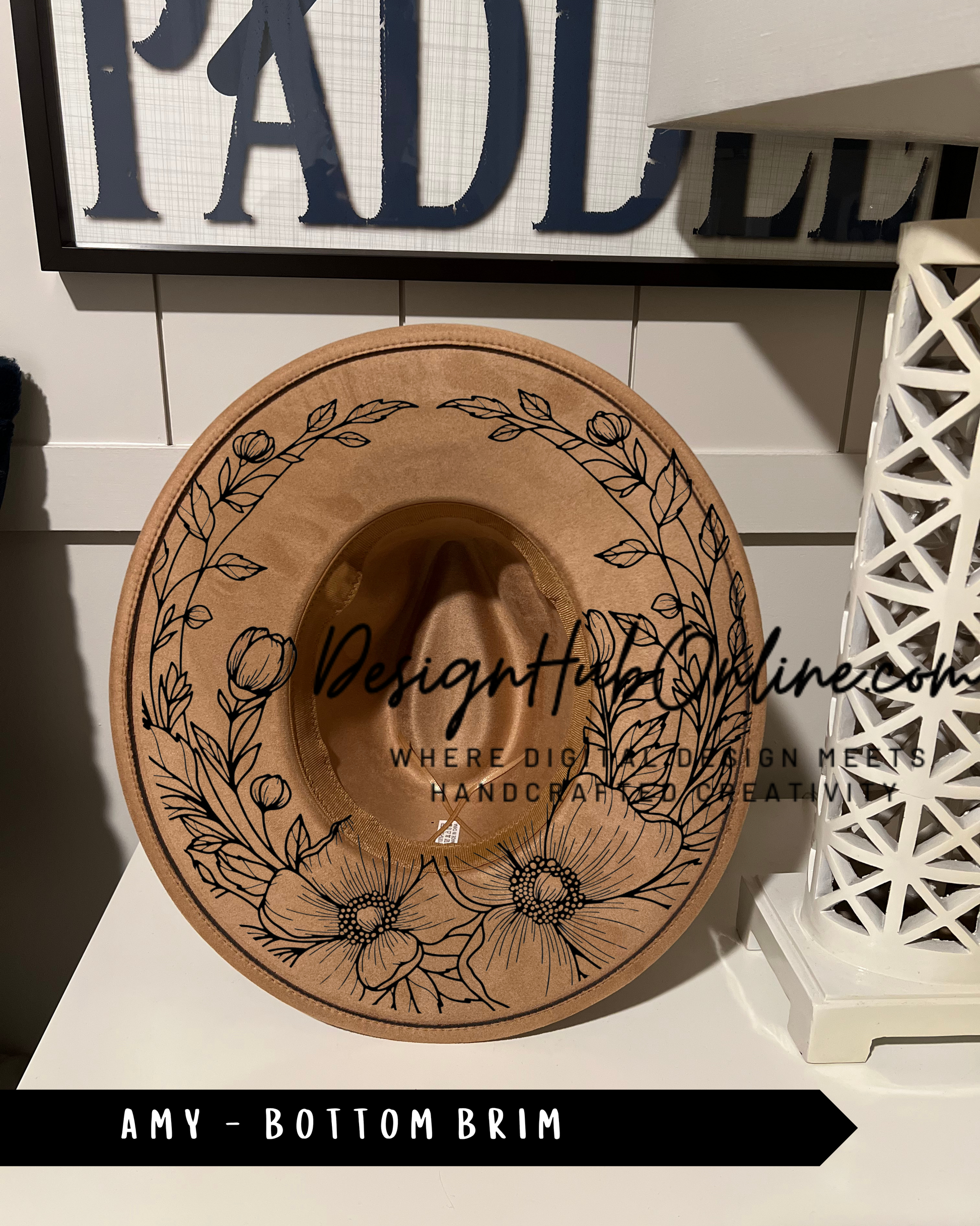 A wooden hat with a floral design on it, placed on a white surface.