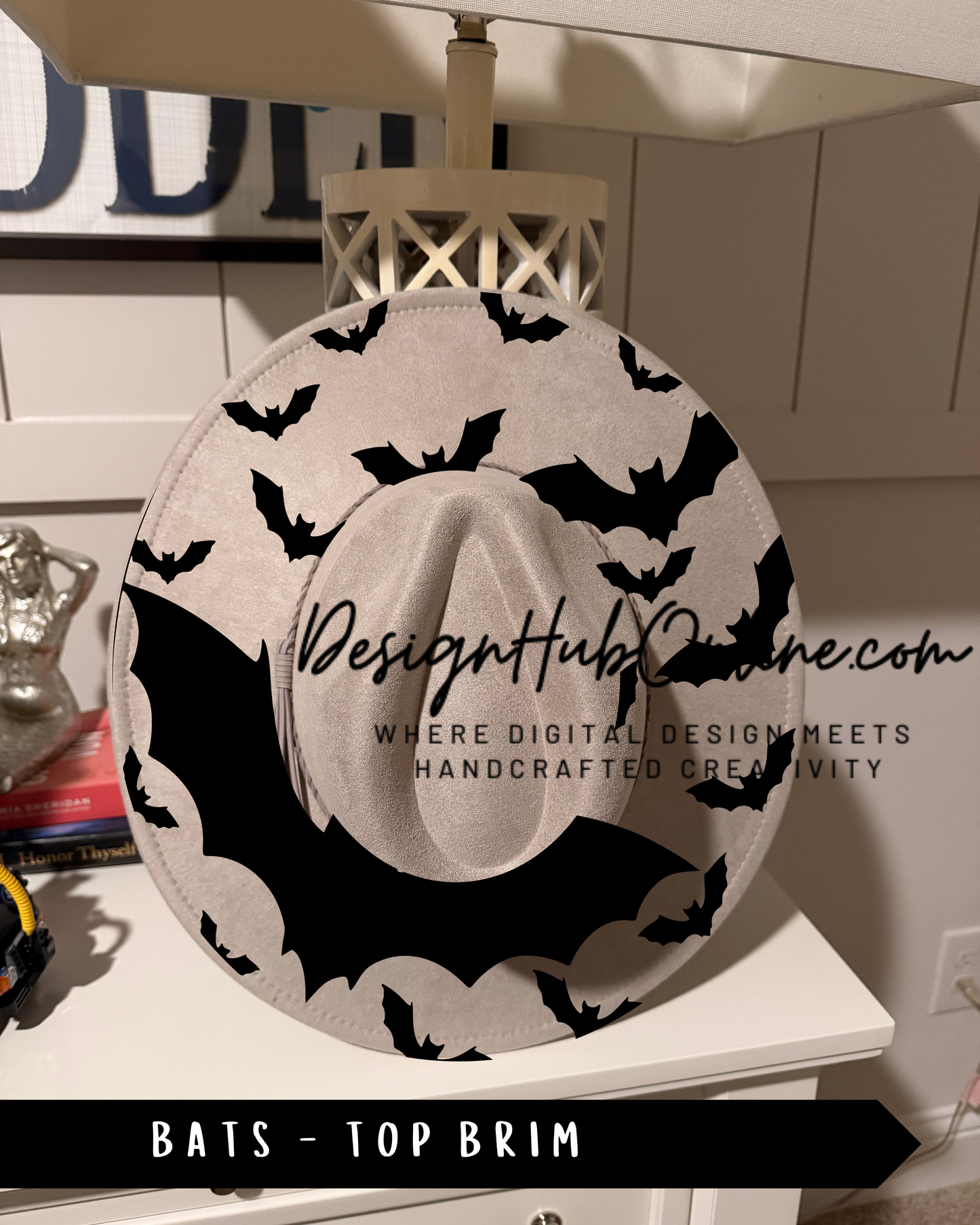 A hat with a bat pattern on it, sitting on a white surface.