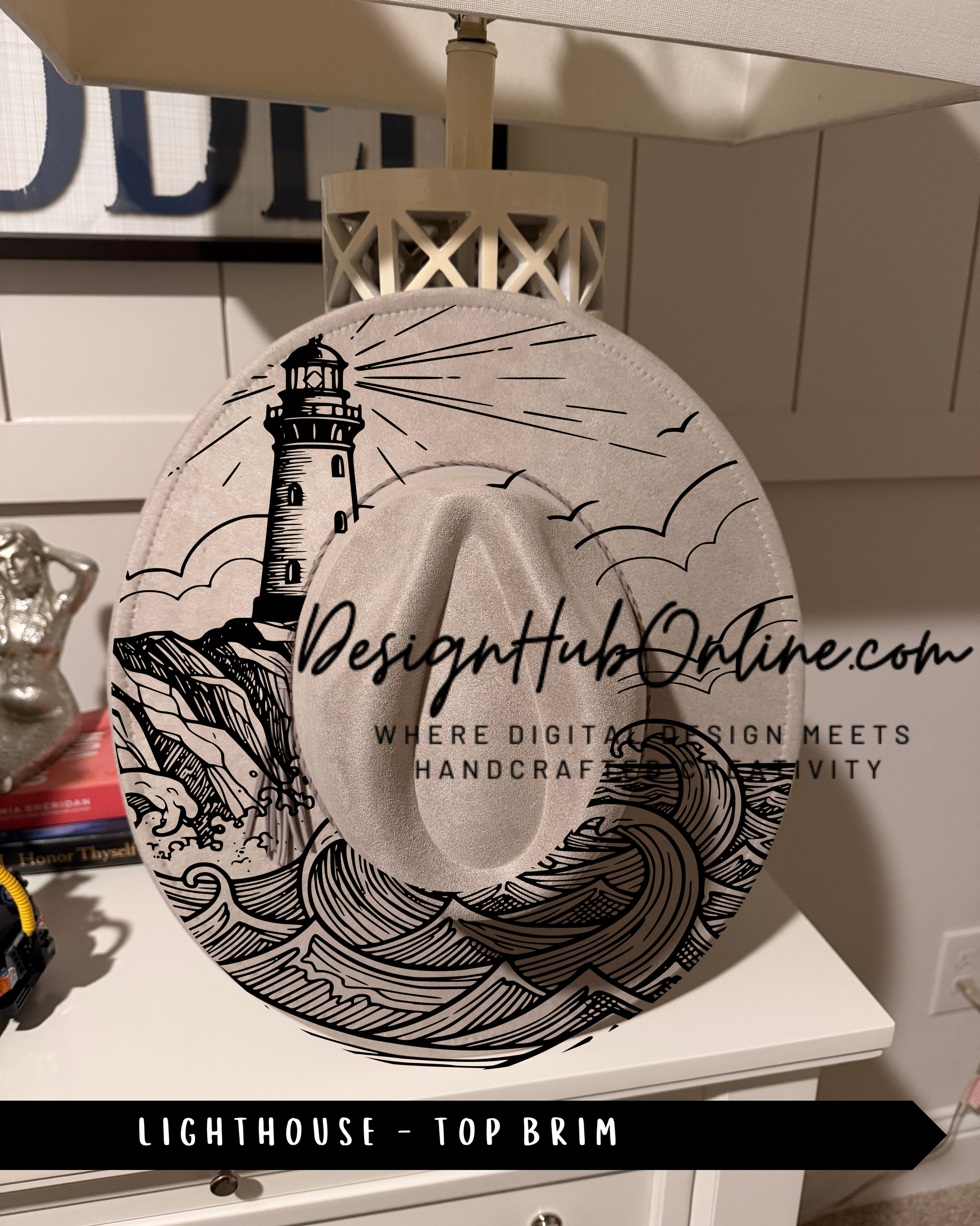 A hat with a lighthouse design on it, sitting on a white dresser.