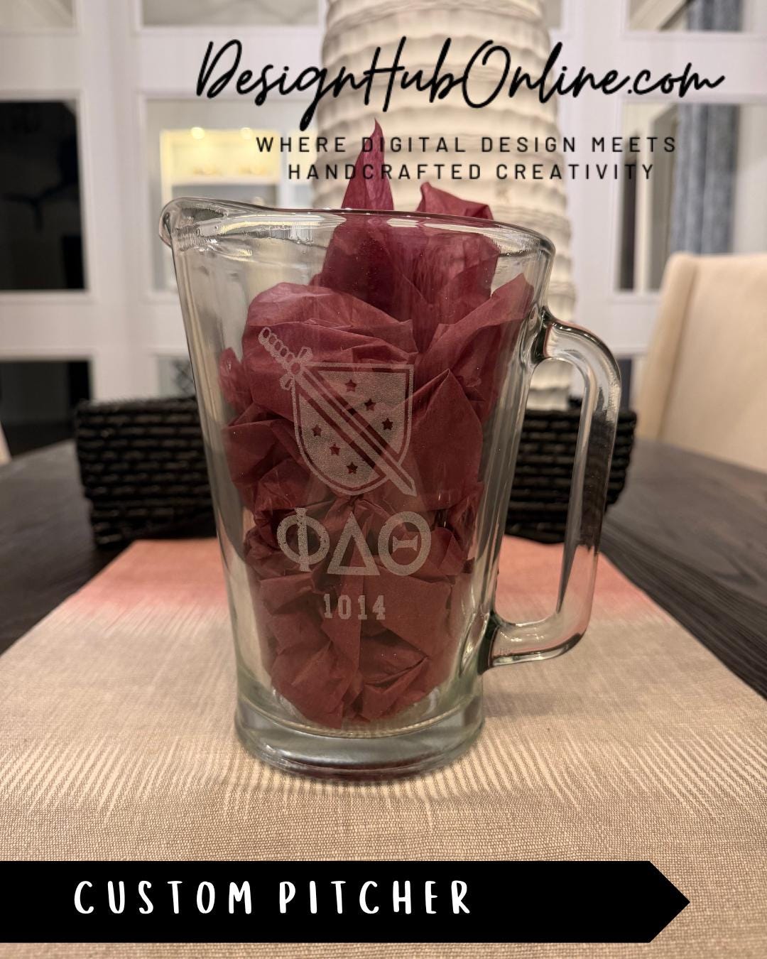 A glass pitcher with a design on it, placed on a table.