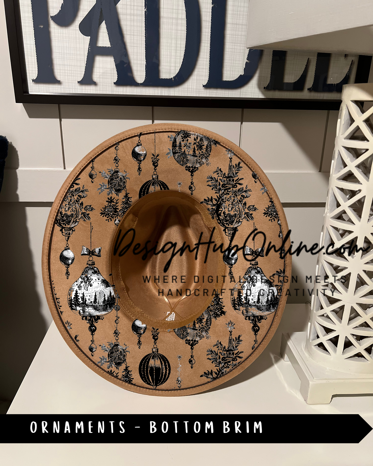 A decorative hat with a pattern of ornaments and a text overlay, placed on a shelf or table.