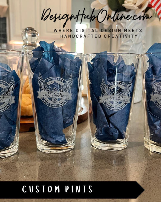 a set of custom pints, each with a unique design, placed on a counter.